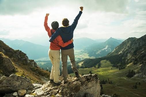 Mann und Frau Siegerpose auf dem Berggipfel.jpg